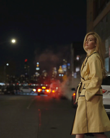 gif of Sarah Pidgeon walking into a street in New York wearing a yellow belted coat