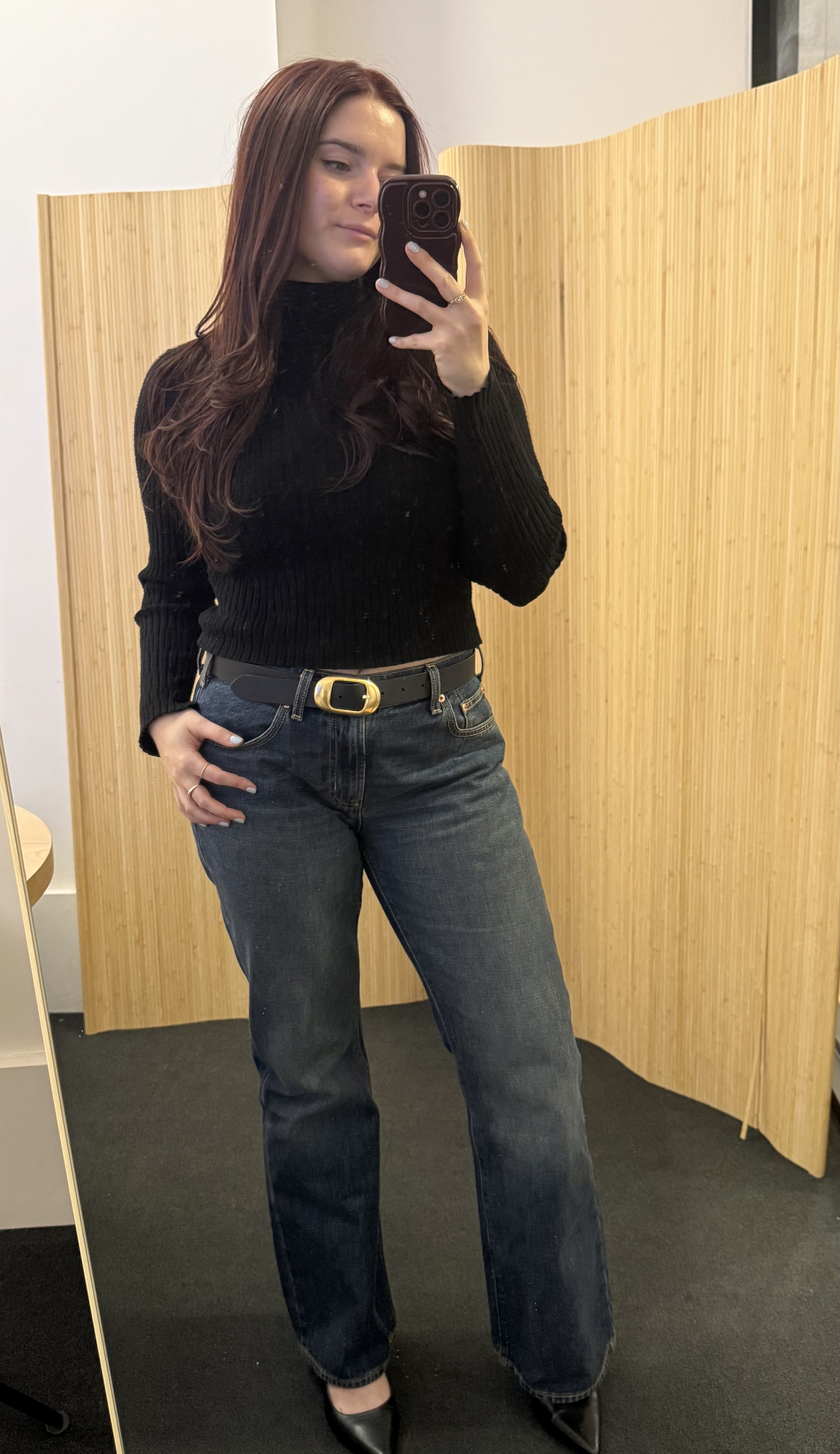 Brooke Knappenberger poses in mirror wearing black turtleneck and gap jeans