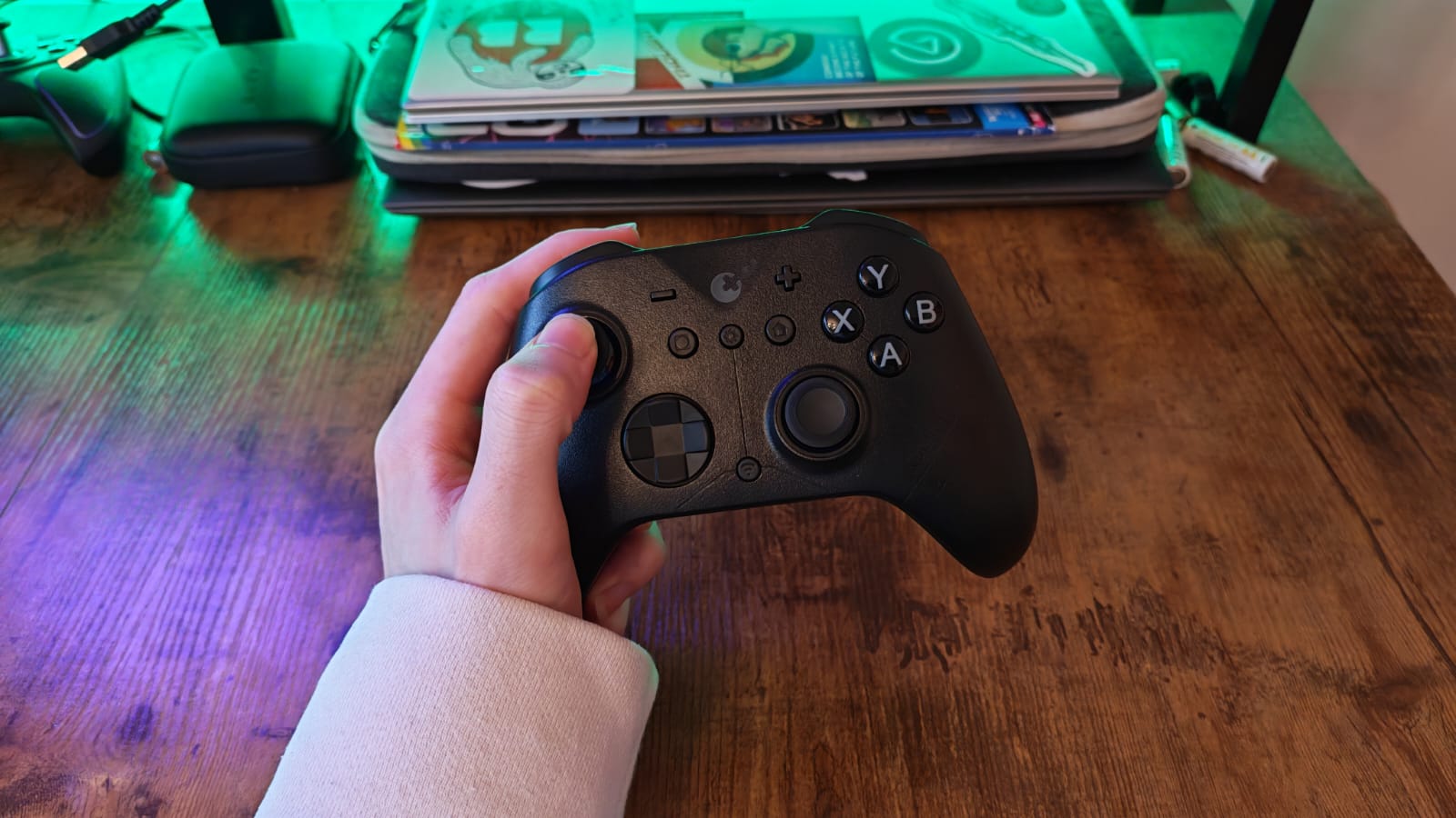 A reviewer holding the GuliKit ES Pro in one hand