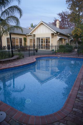 pool fence ideas: weatherboard house with pool