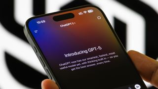 A person holds a smartphone showing the Introducing GPT-5 interface in the ChatGPT app.