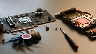 Disassembled graphics card XFX GPU AMD fan screws screwdriver on a table