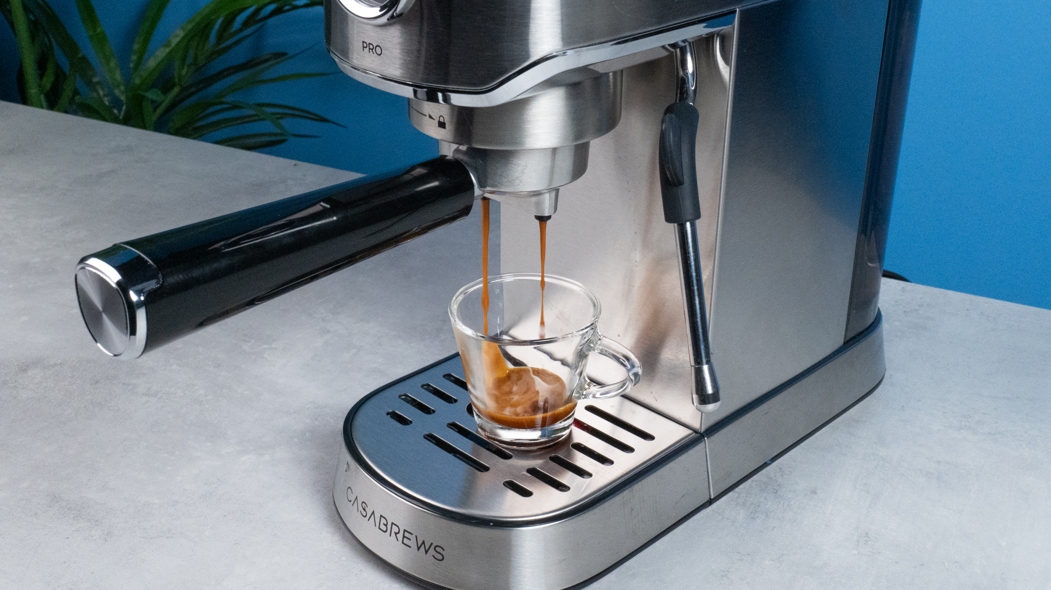 The Casabrews 5418 Pro espresso machine in stainless steel with a steam wand on the right side and three buttons on the front of the machine and a pressure gauge underneath