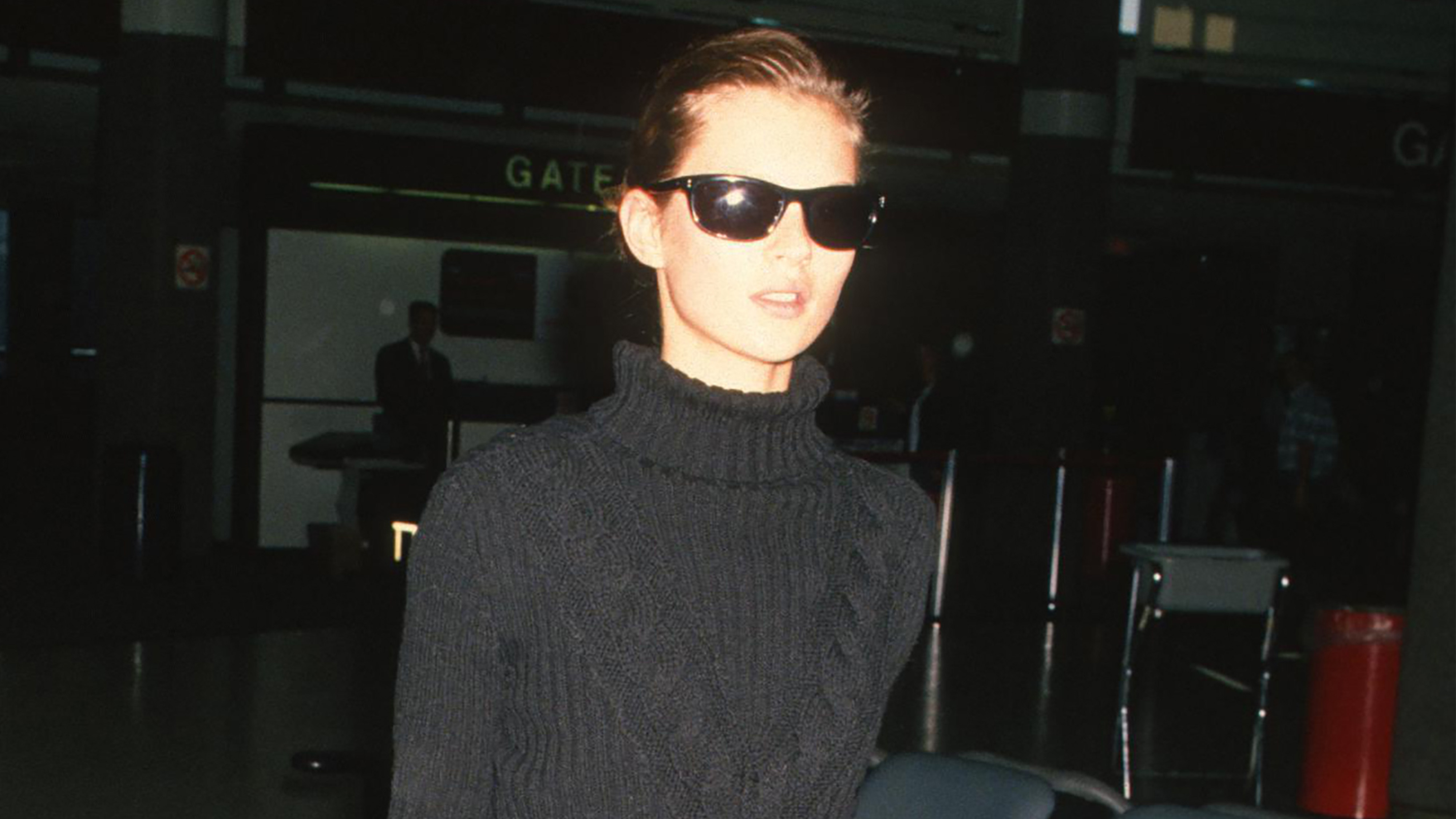 Kate Moss wearing a cable-knit sweater and sunglasses.