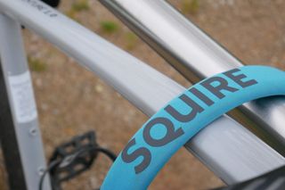 the blue neoprene sleeve and the squire logo showing the lock securing an electric bike