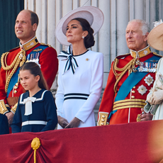 Prince William and King Charles wear military uniform as they stand on the Buckingham Palace balcony with Kate Middleton, who wears a white dress with navy accents