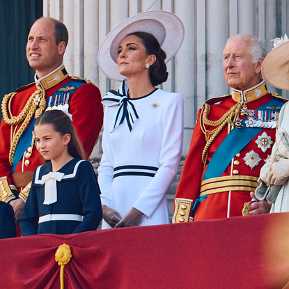 Prince William and King Charles wear military uniform as they stand on the Buckingham Palace balcony with Kate Middleton, who wears a white dress with navy accents