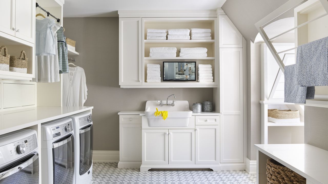 A white laundry room with tiled floors and clothes rail illustrating laundry room storage ideas