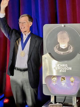 Chris Ferguson, who on the last of his three flights commanded the final mission of the space shuttle program, poses with his plaque to be hung in the U.S. Astronaut Hall of Fame.