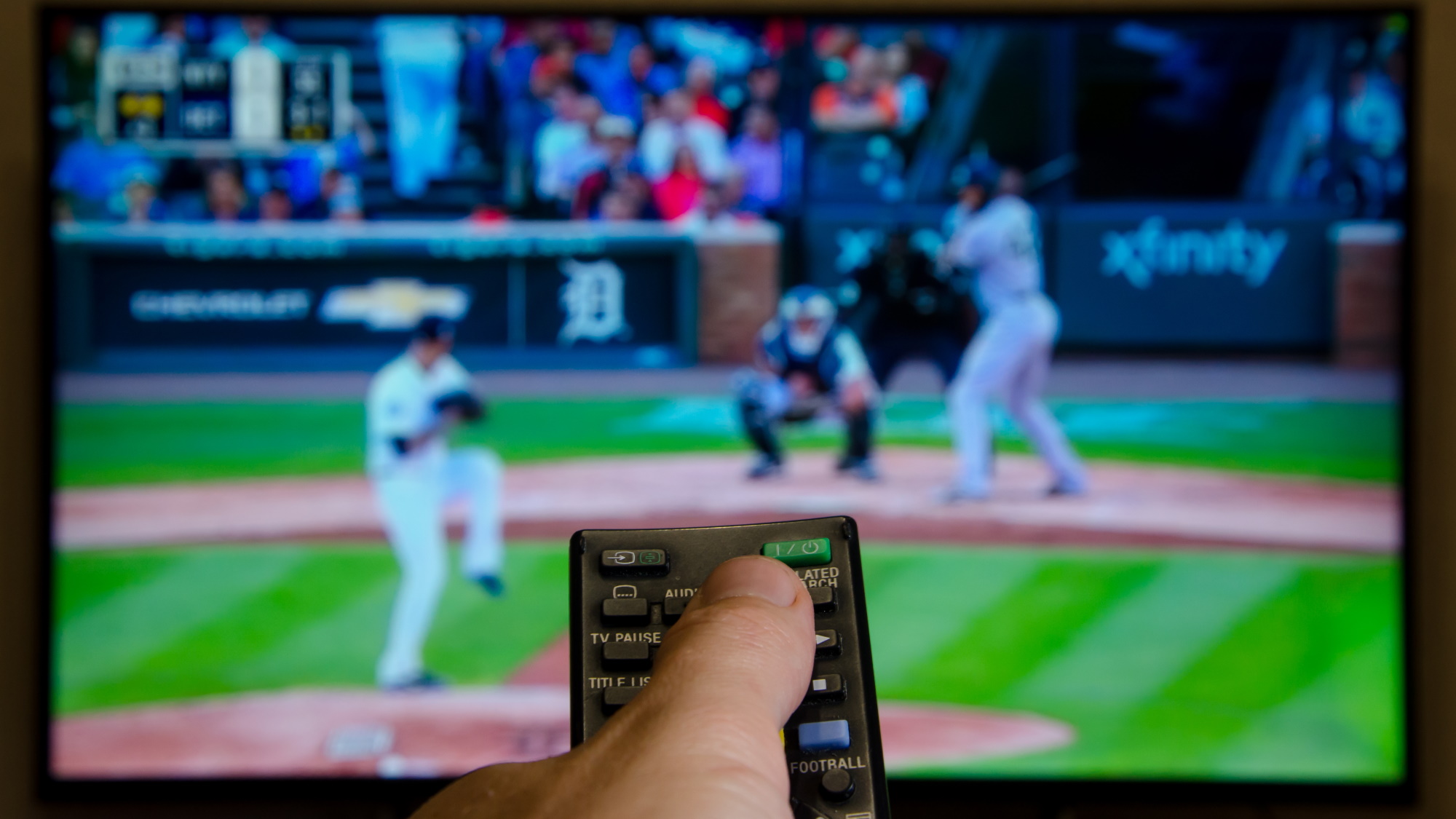 Person using remote control to watch baseball on TV