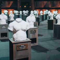 torso busts arranged in a showroom, with plaques underneath, on 'physical 100' season 2