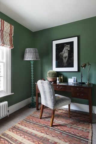 Dark green home office with patterned curtain and pelmet