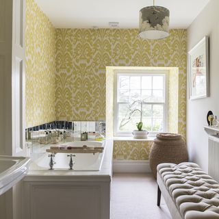 bathroom with white wall with yellow shades and bathtub with mirrored tiles