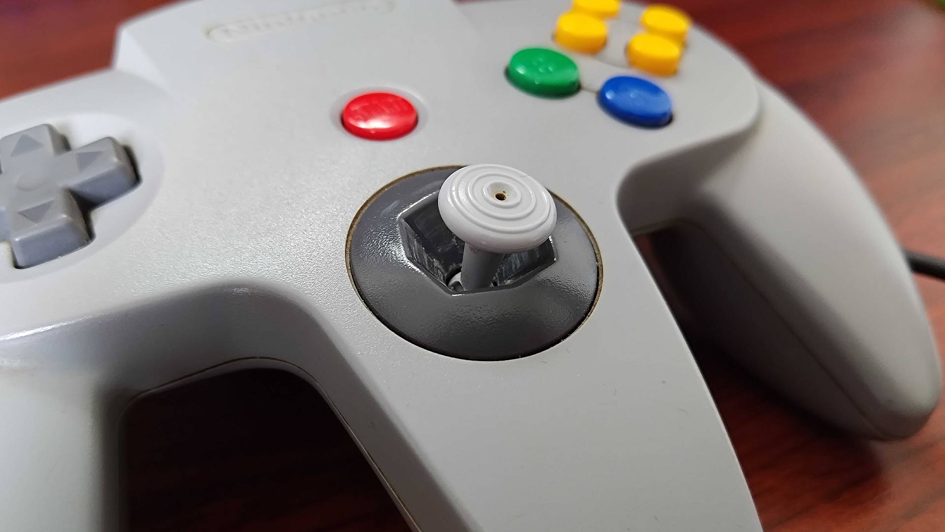 Close up of N64 controller front with visible dirt in grooves.