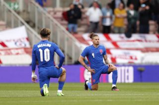 England’s Jack Grealish and Kalvin Phillips take a knee before the Romania game