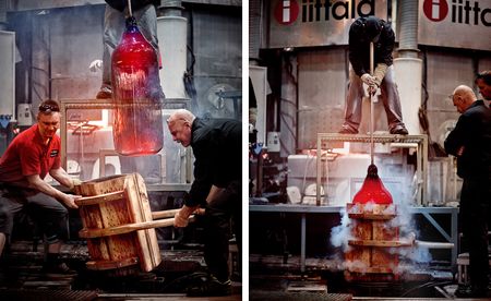 Men pulling large red glass piece