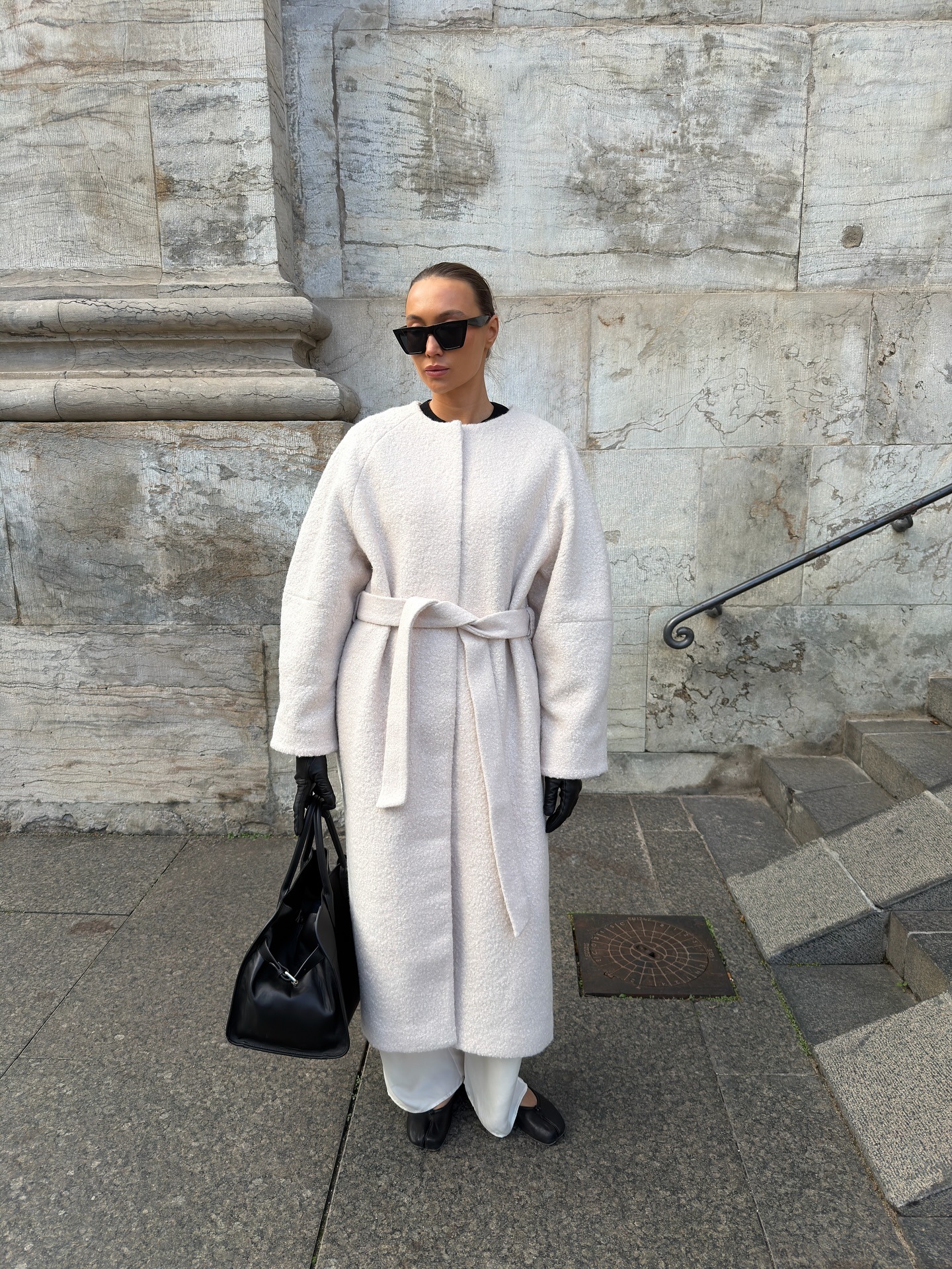 Woman wearing white ivory coat for winter 2026.