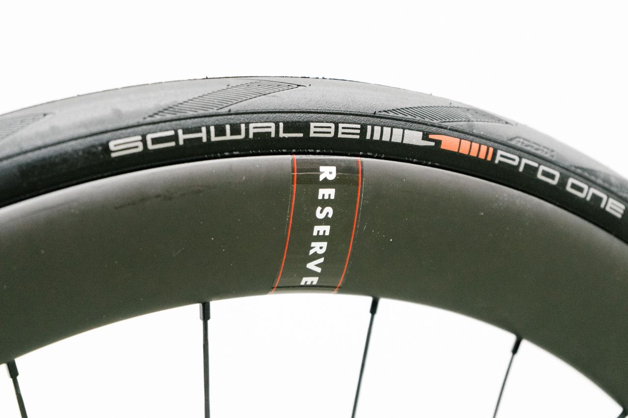 An aero road wheel stands against a white wall