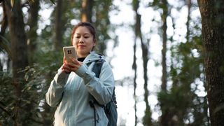 Woman looking at phone while hiking