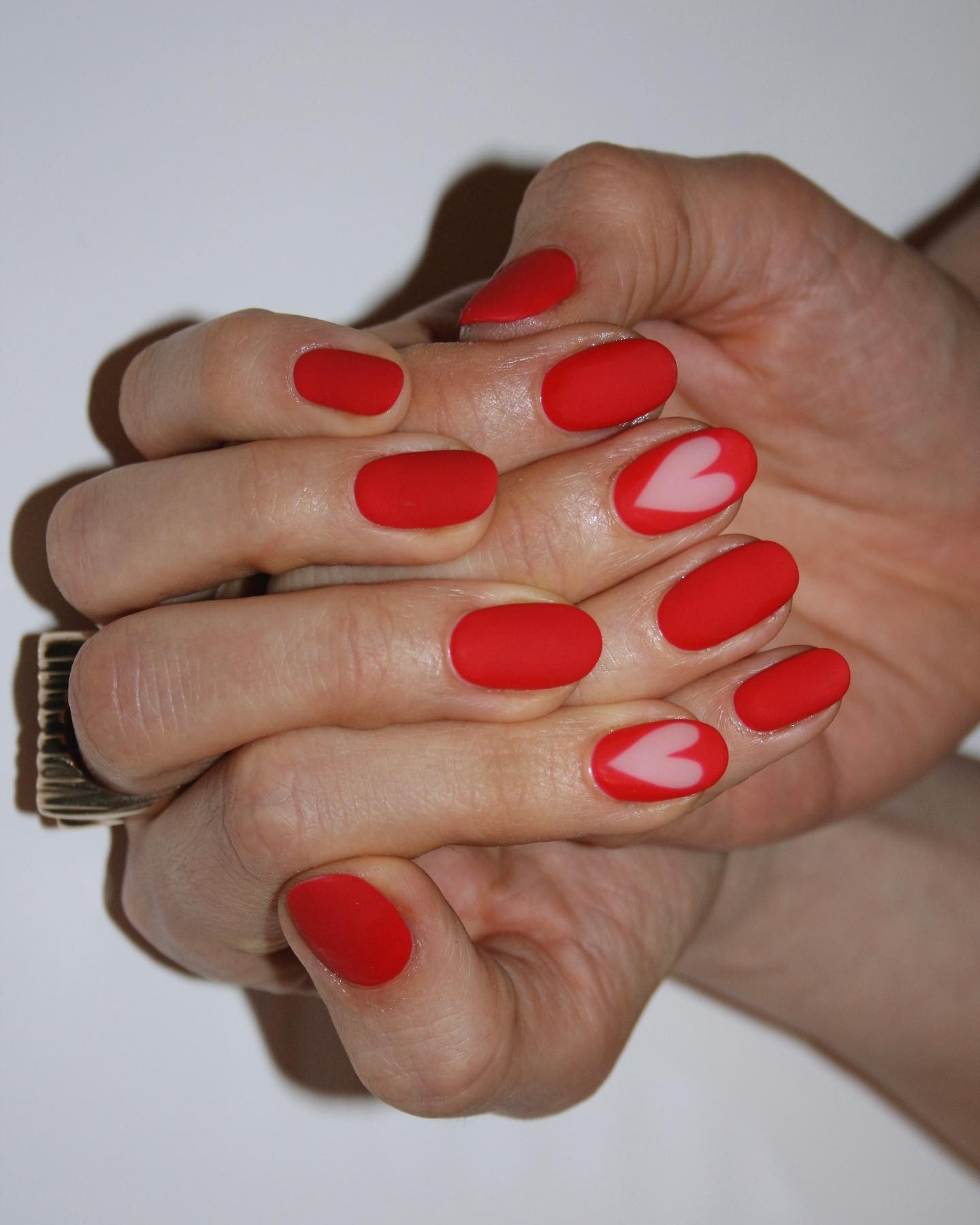 A red manicure with cut-out hearts
