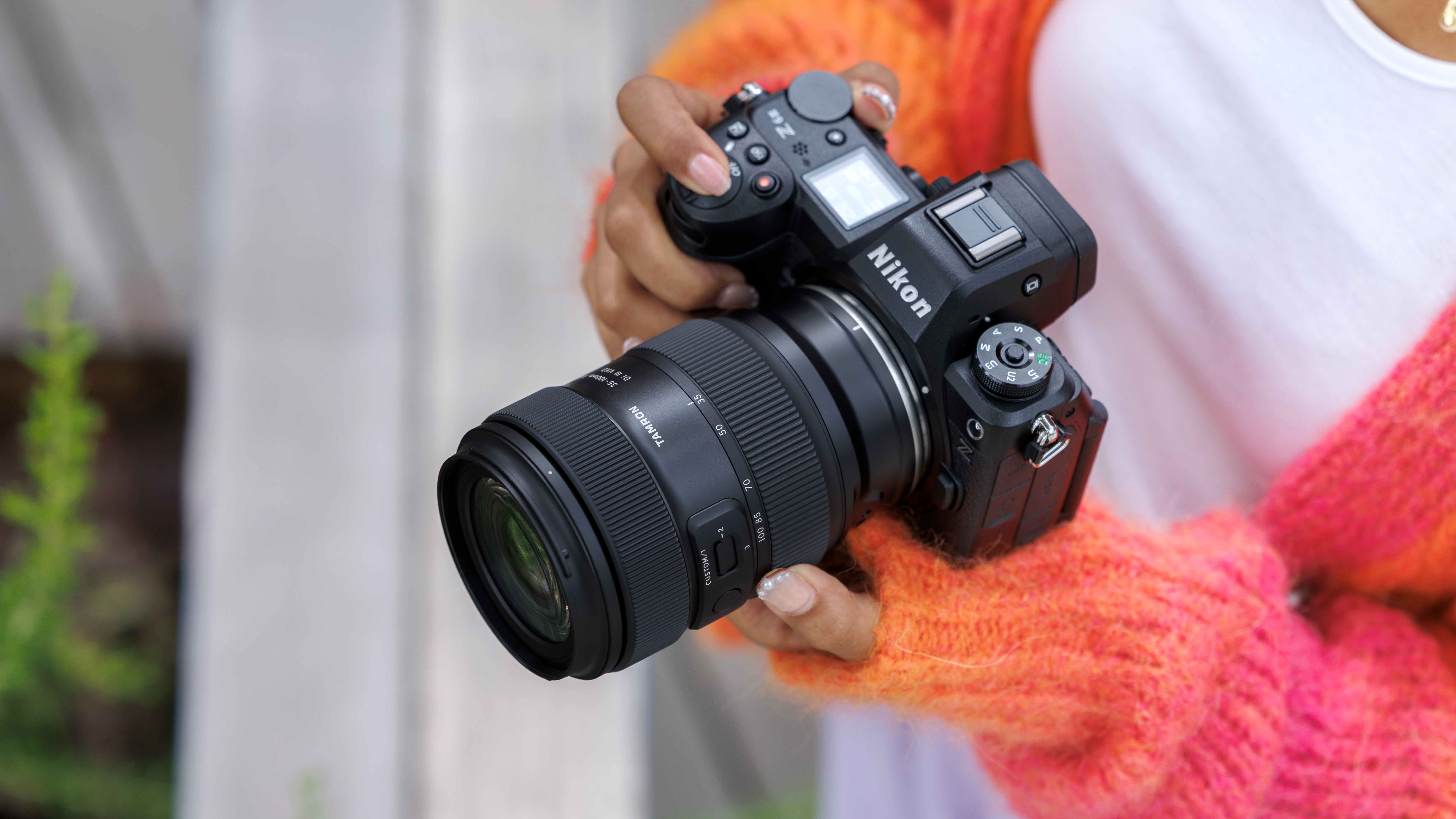 The Tamron 35-100mm f/2.8 Di III VXD lens in a photographer's hands
