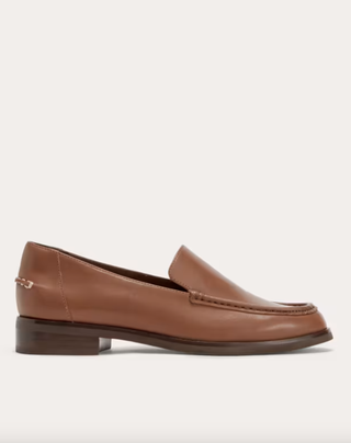 Everlane brown loafers in front of a plain backdrop