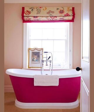 Pink bathroom scheme with statement hot pink freestanding bath and pink trim window blind