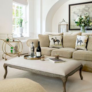 room with coffee table footstool sofa cushion and white vase