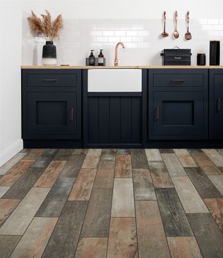 rustic wooden flooring in dark blue kitchen
