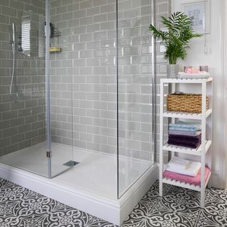 bathroom with grey brick wall shower cabin and white shelve