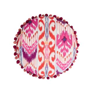 A pink and orange round Ikat outdoor cushion