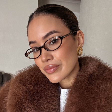 Image of a woman wearing natural makeup and glasses.