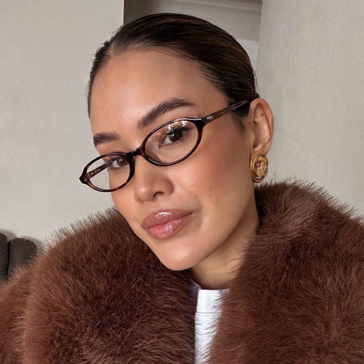 Image of a woman wearing natural makeup and glasses.