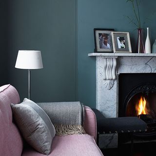 blue living room with pink sofa and fire place