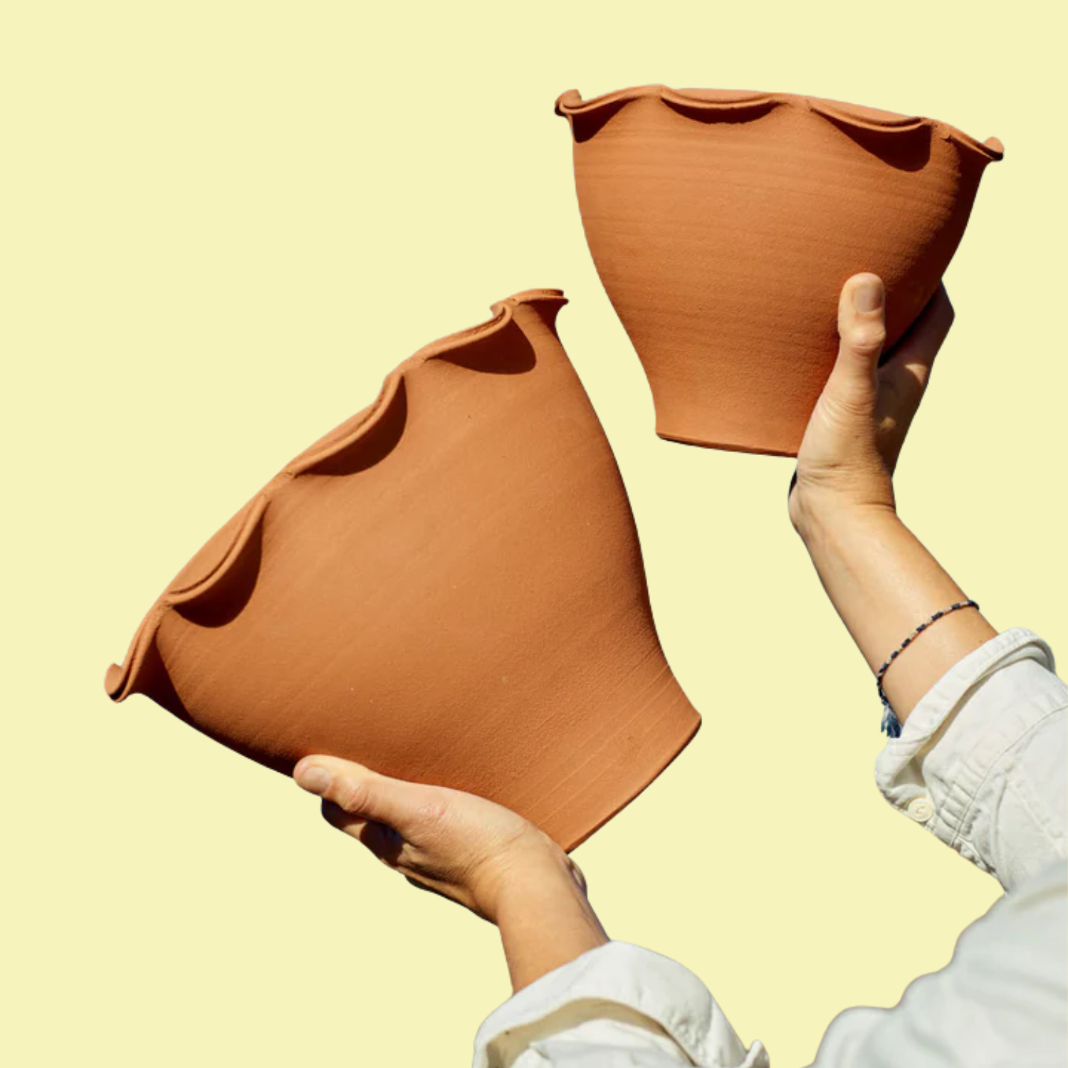 A set of two terracotta pots with ruffle hems