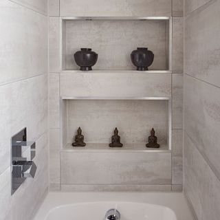 bathroom with grey tiled walls and white washbasin