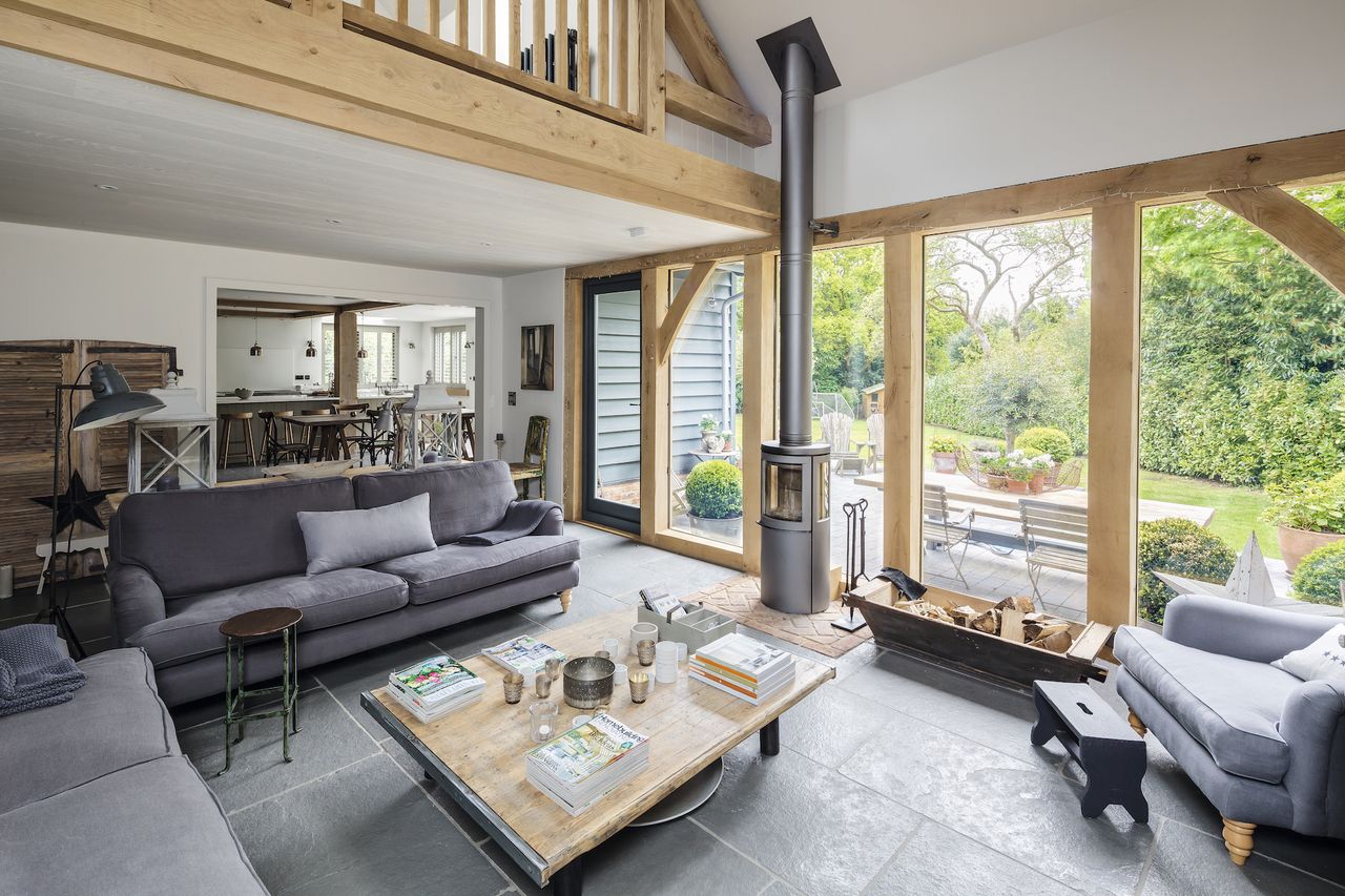 living room with tall log burner and view to dining room