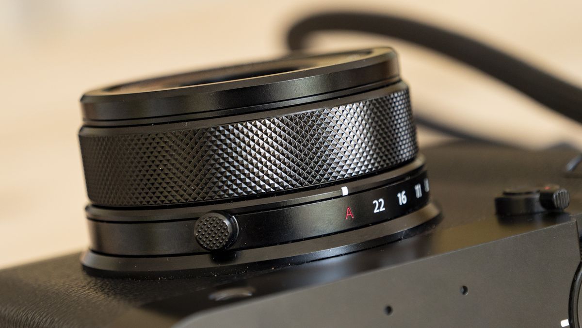 All-black Fujifilm GFX100RF rangefinder-style camera on a wooden table