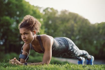 Young sporty woman doing a plank in the park