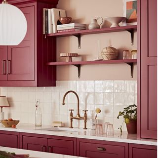 kitchen with pink cabinets and shelving, white tiled splashback and pendant lighting