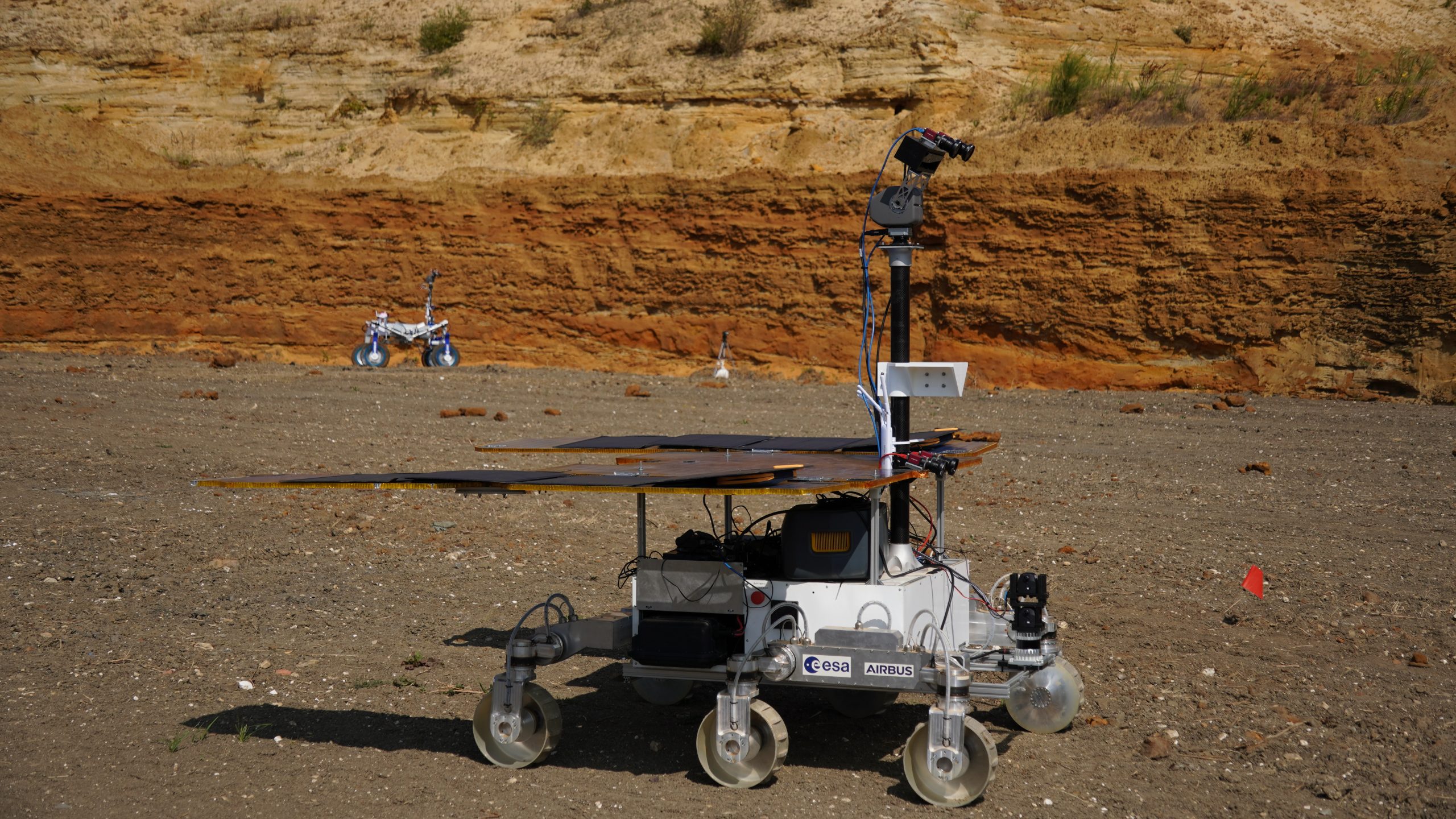 un rover de cuatro ruedas conduce sobre la tierra roja en un sitio de construcción