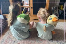 my goddaughters sitting on the floor and facing away with Rocky the Crocodile and Bailey the Duck Hug-A-Lumps over their shoulders