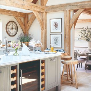 Kitchen with exposed oak beams, large kitchen island and breakfast bar with view through an arch to the dining room