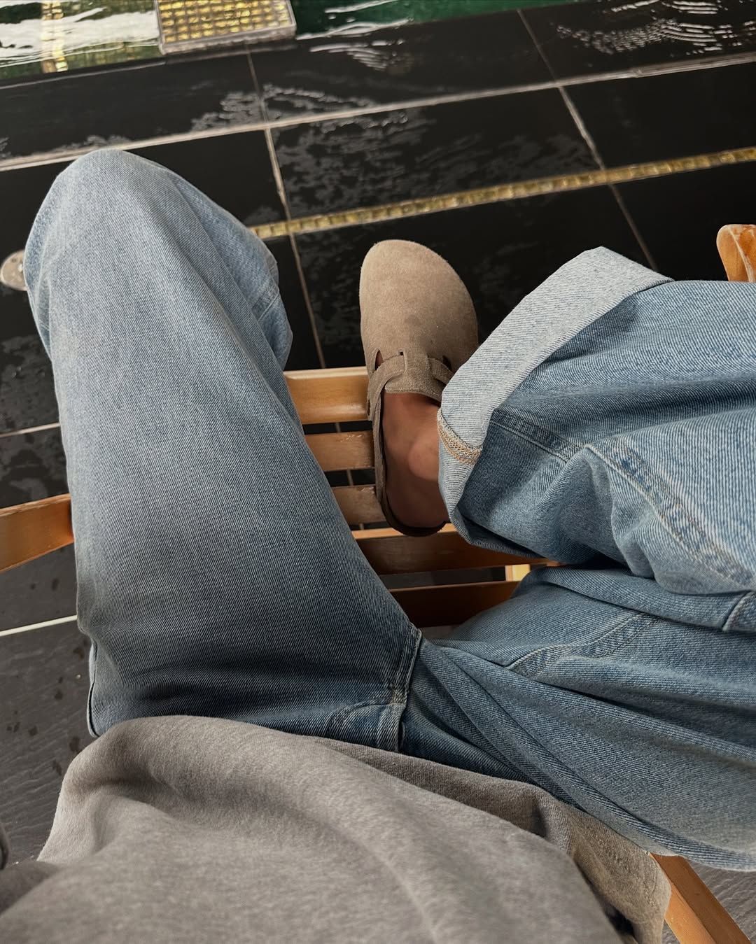 Marianne in light wash jeans and Birkenstock clogs