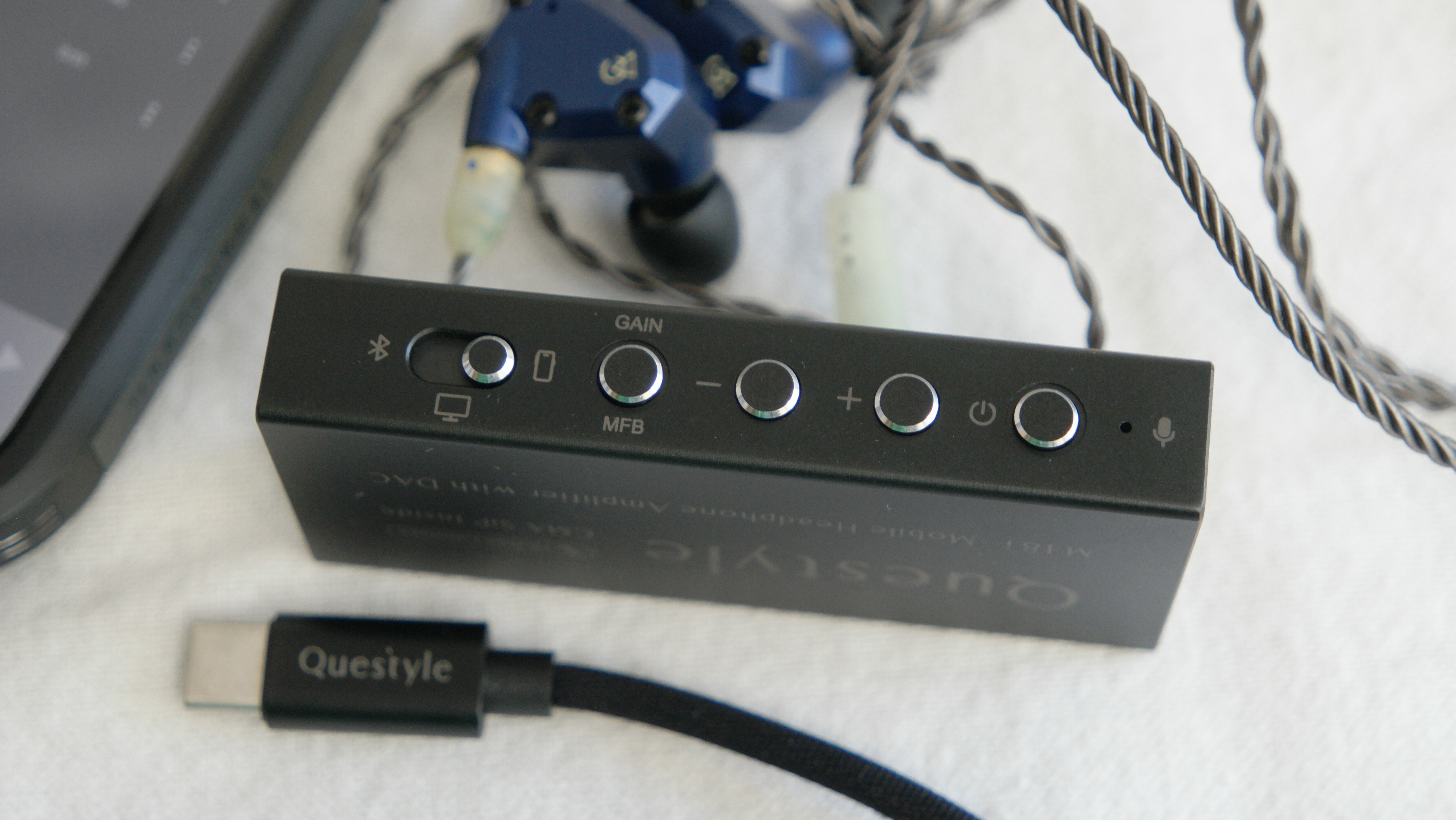 Questyle M18i showing buttons panel, USB-C cable, and Campfire Audio IEMs