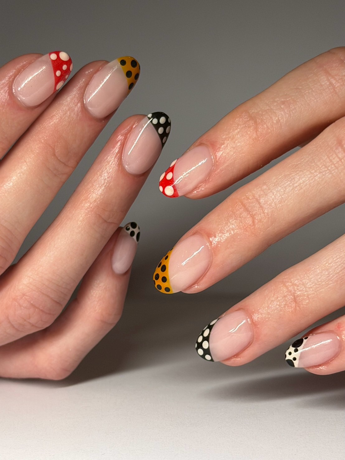 Asymmetrical French manicure with Kasuma polka dots.
