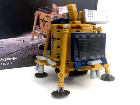 a model of a gold and blue lunar lander made out of toy building blocks