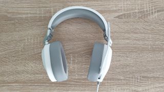 Corsair HS65 Surround review: white and grey headset from above on a wooden desk