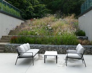 sloping garden designed with gabion walls and planted borders by Bowles & Wyer