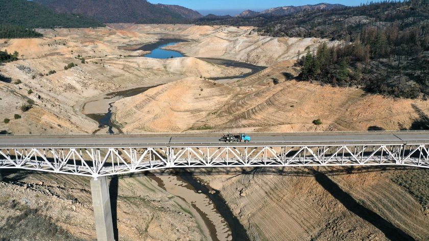 Aerial photo of a bridge over a large, mostly dry lake bed. 